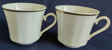 Lade das Bild in den Galerie-Viewer, Zwei weiße Porzellantassen mit Goldrand, gewölbtem Design, Reliefmotiv und geschwungenen Linien im 2er Set von Retsch &amp; Co.
